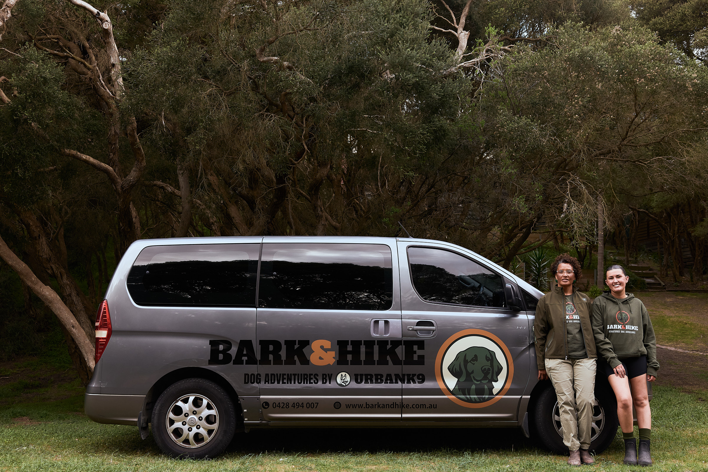 The Bark & Hike adventure van with two team members beside it